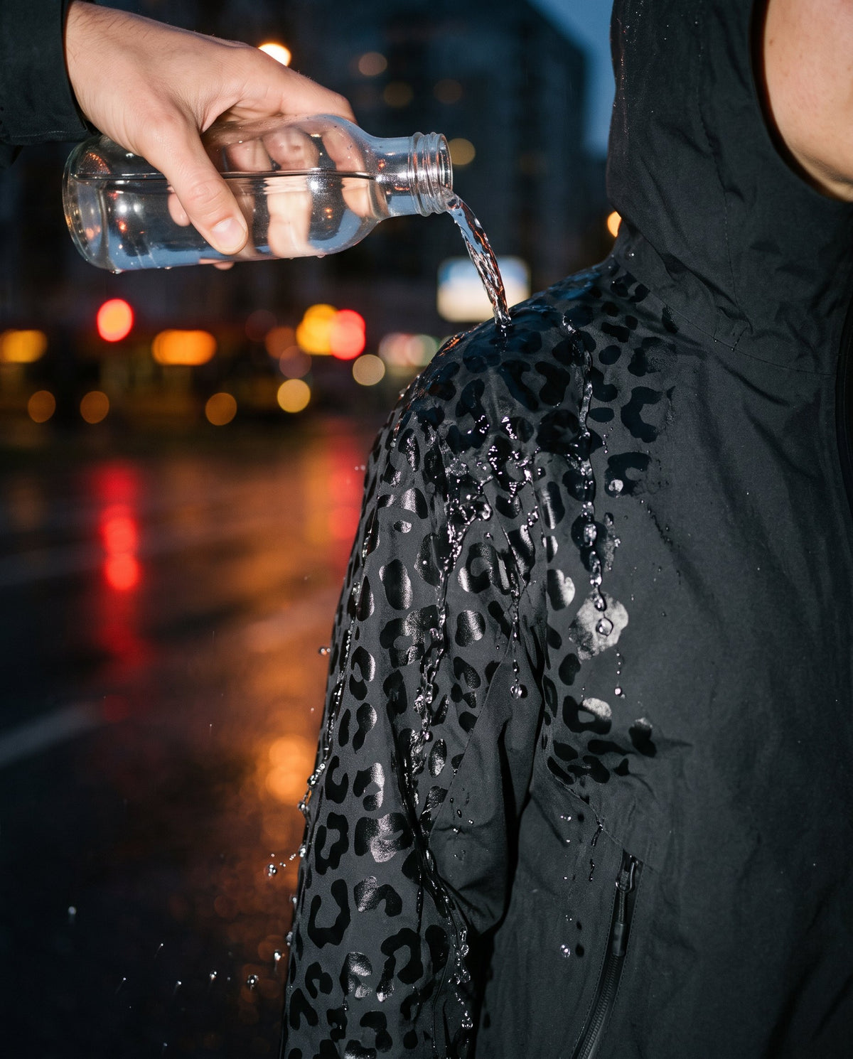 Woda z butelki wylewana na rękaw kurtki NIMBA odsłania wzór panterki